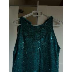Petrol kleurige jurk met glittertjes.