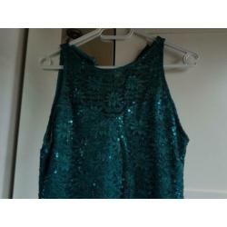Petrol kleurige jurk met glittertjes.