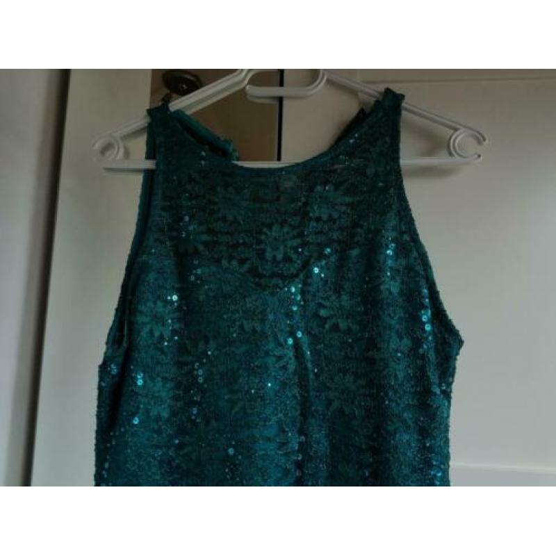 Petrol kleurige jurk met glittertjes.